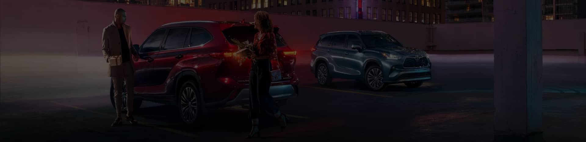 people standing around cars at night