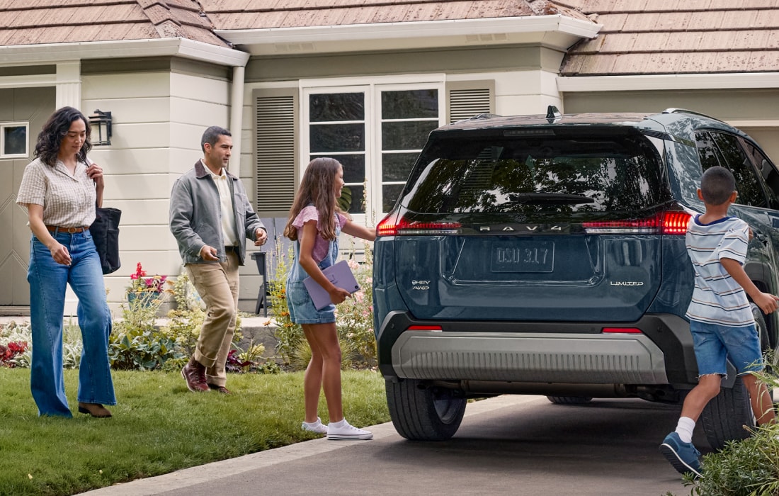 family approaching a Toyota SUV in the driveway