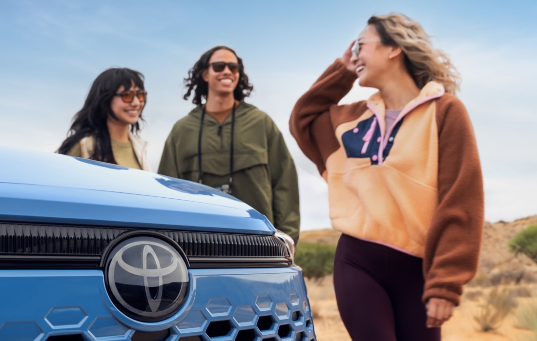 Three friends near a Toyota SUV near the beach